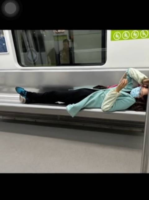 女子横躺玩手机被吐槽素质差 小伙“地铁盖被”化解尴尬：网友点赞高情商  第1张